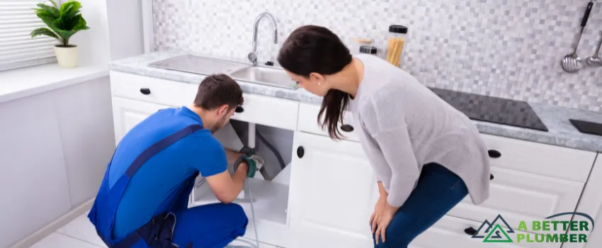 ABP - A professional helping a woman with her drain.