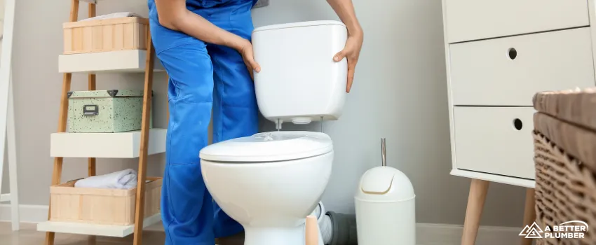 ABP - Plumber installing toilet in restroom