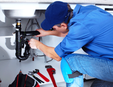  a professional plumber fixing sink pipe fittings  