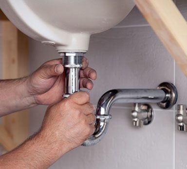  plumber fitting a bathroom sink pipe 