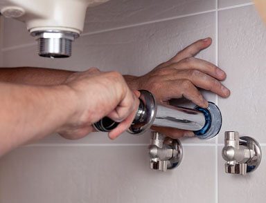 a plumber attaching a drain on the wall