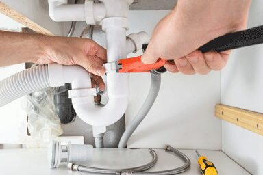a plumber fixing pipe fittings