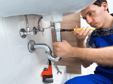  a plumbing technician fixing a bathroom sink pipe 